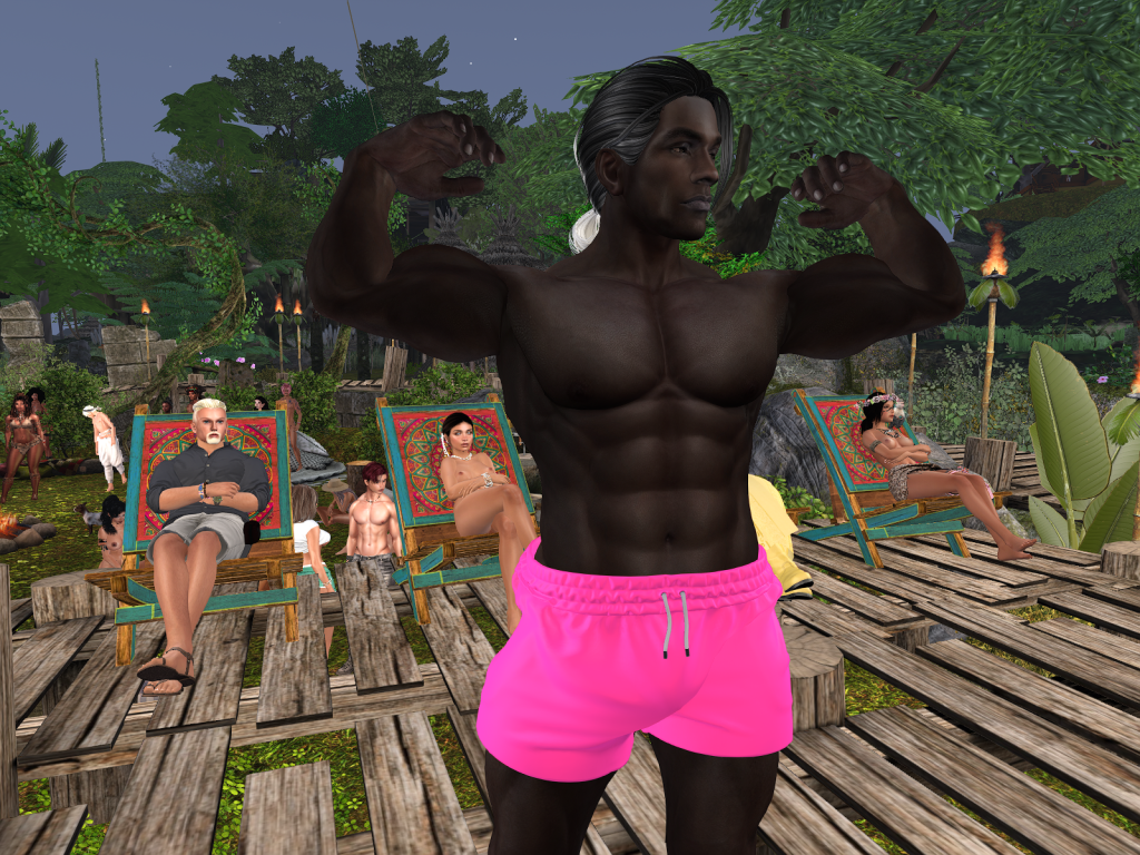Shirtless villager flexes muscles as others relax on wooden platforms in the jungle camp