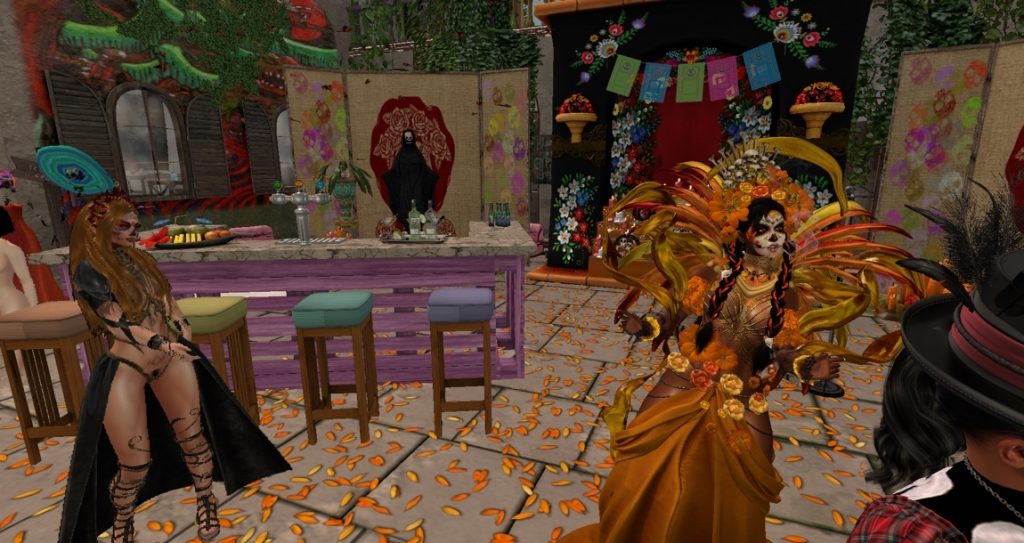 Two native women in colorful costumes dance amid vibrant decorations in the jungle camp