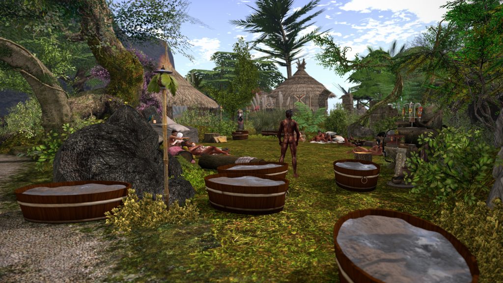 Unclothed villager stands in the jungle camp near huts, surrounded by others resting and lounging