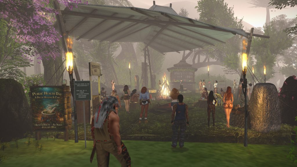 A group gathers around a bonfire under a canopy in the jungle camp for a healing ceremony