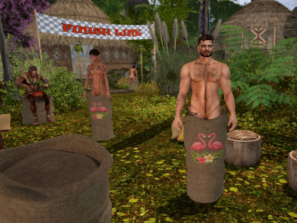 Shirtless man stands inside a decorated sack at the finish line in the jungle camp