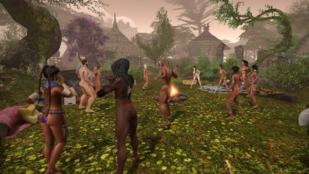 Unclothed villagers dance around a fire in the jungle camp