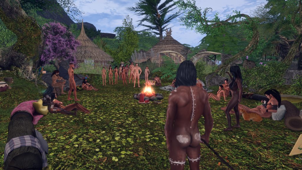 Unclothed villager approaches the campfire as a circle of villagers gathers in the jungle camp