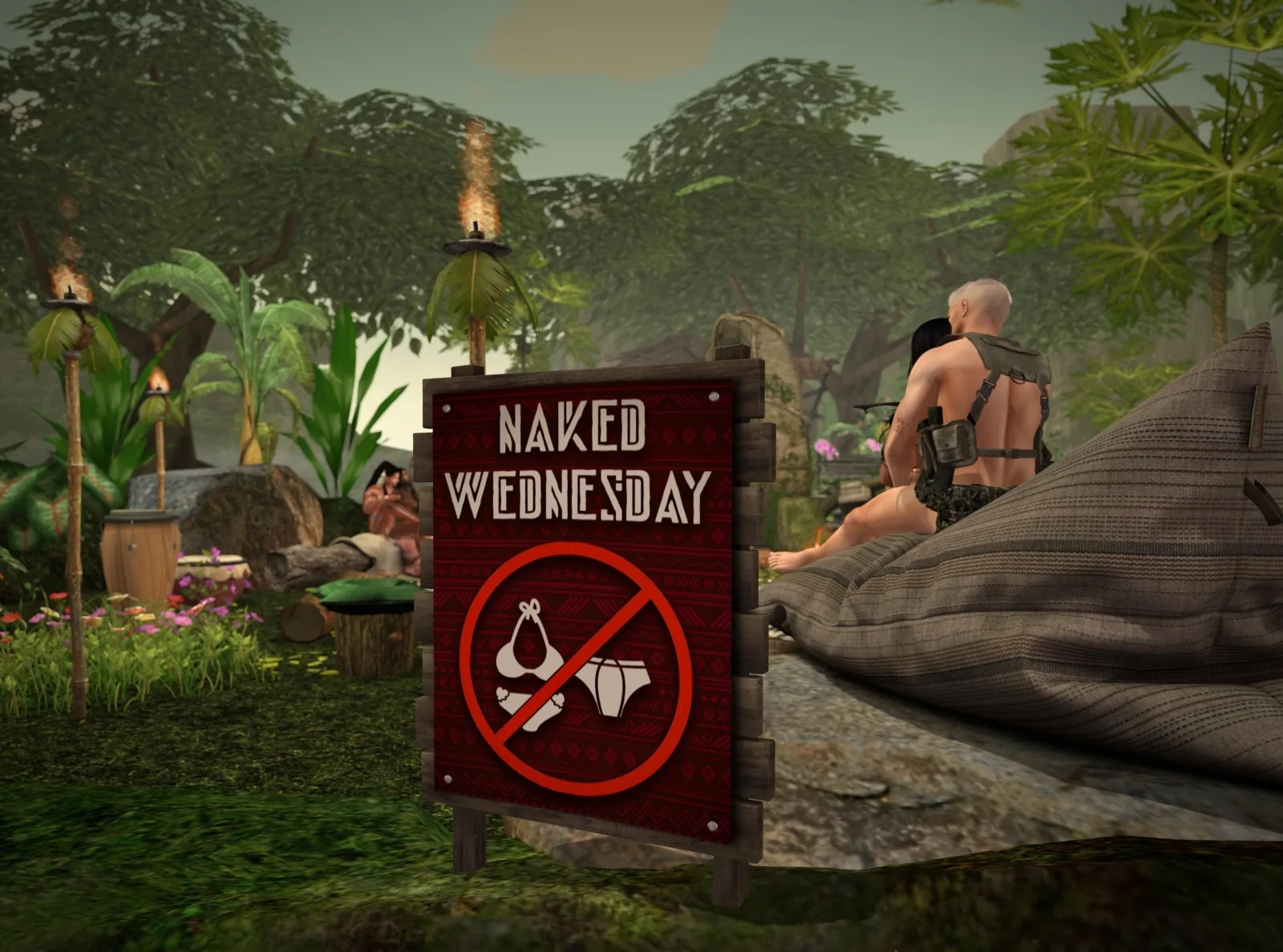 A "Naked Wednesday" sign is displayed in a lush, tropical setting, with people relaxing nearby amidst greenery and torches.