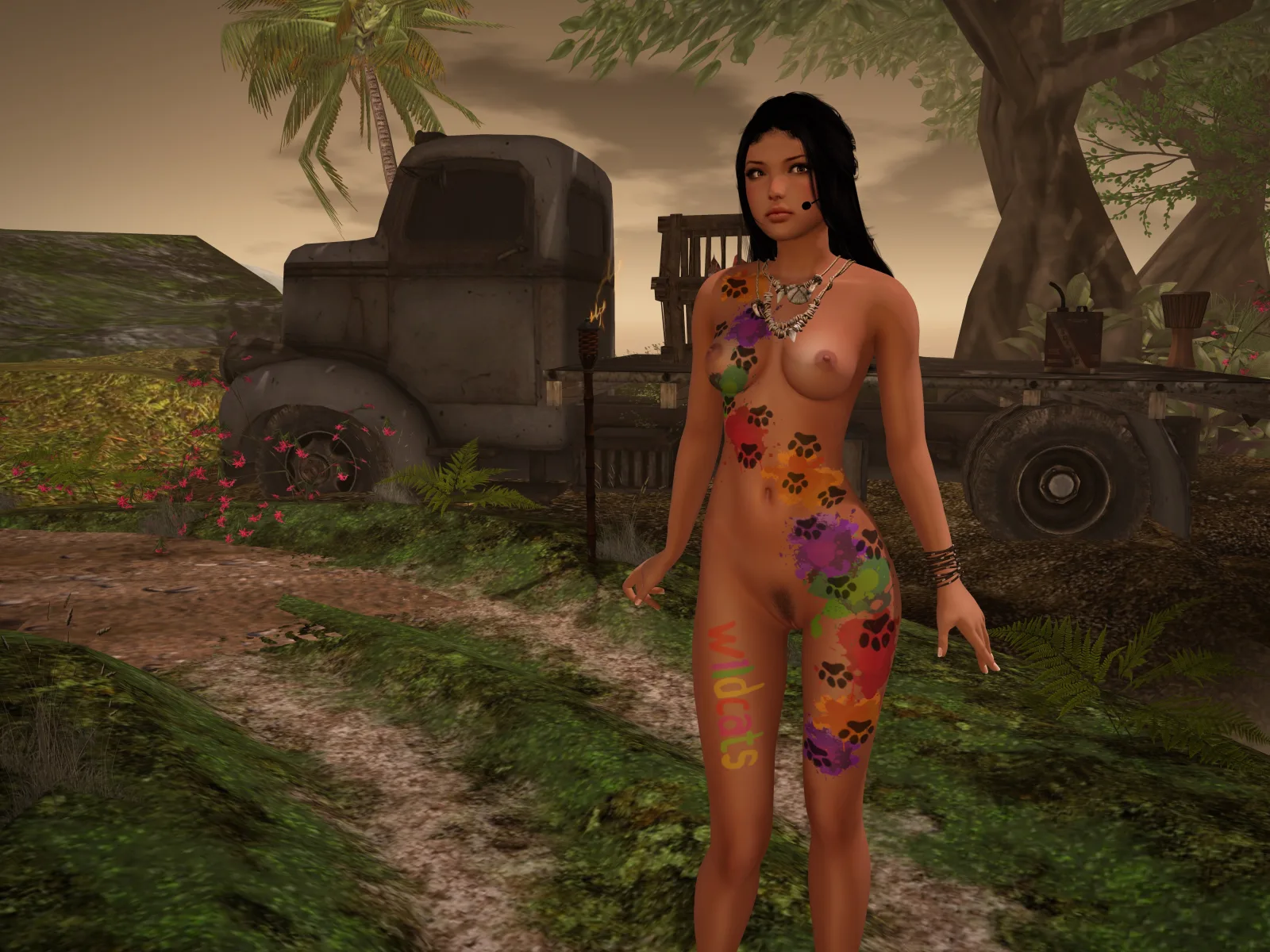 A woman with colorful body paint stands in a lush setting with an old truck and tropical trees in the background.