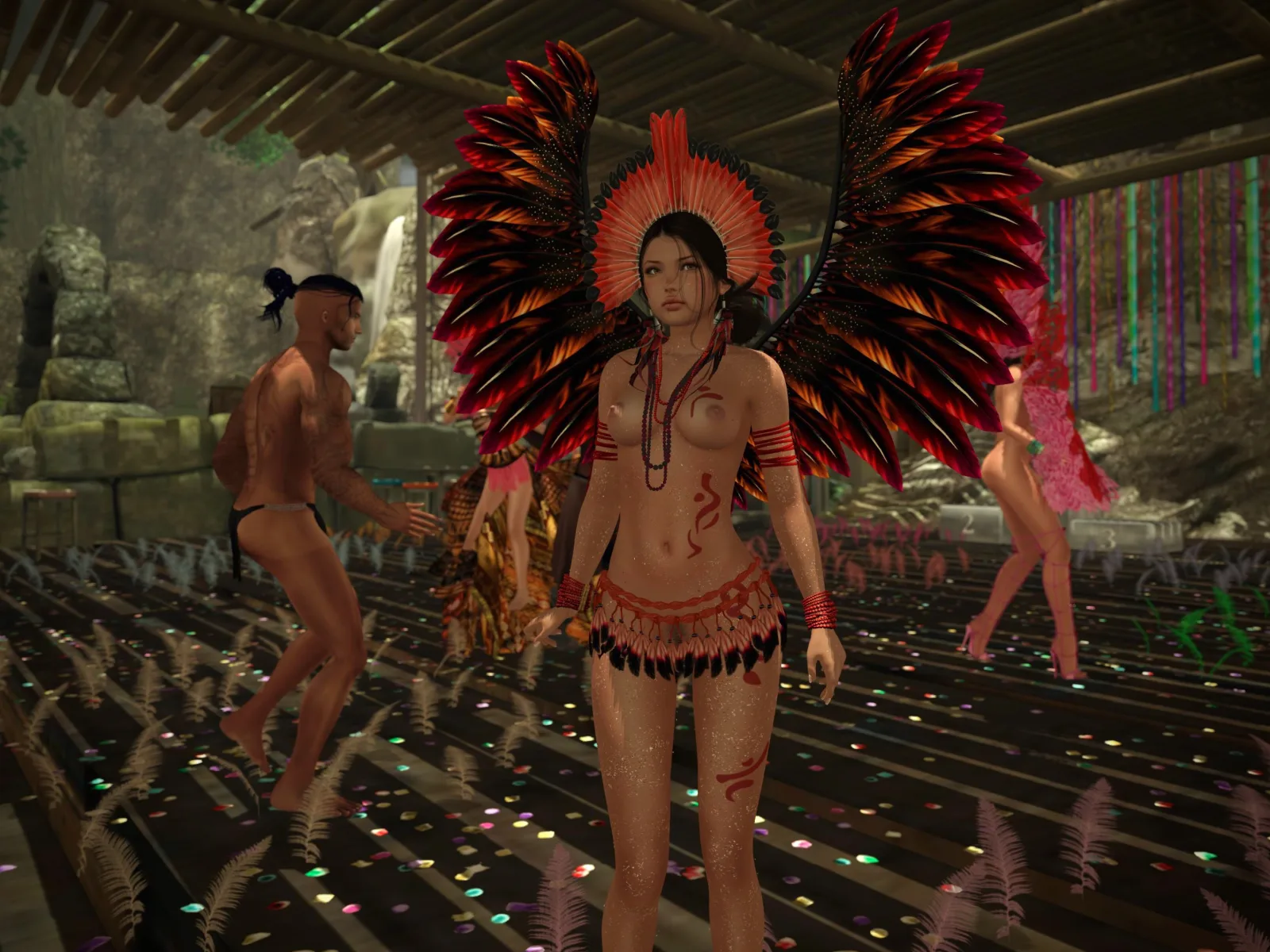 A person in a colorful feathered costume and headdress at a festive celebration, with others dressed similarly in the background.