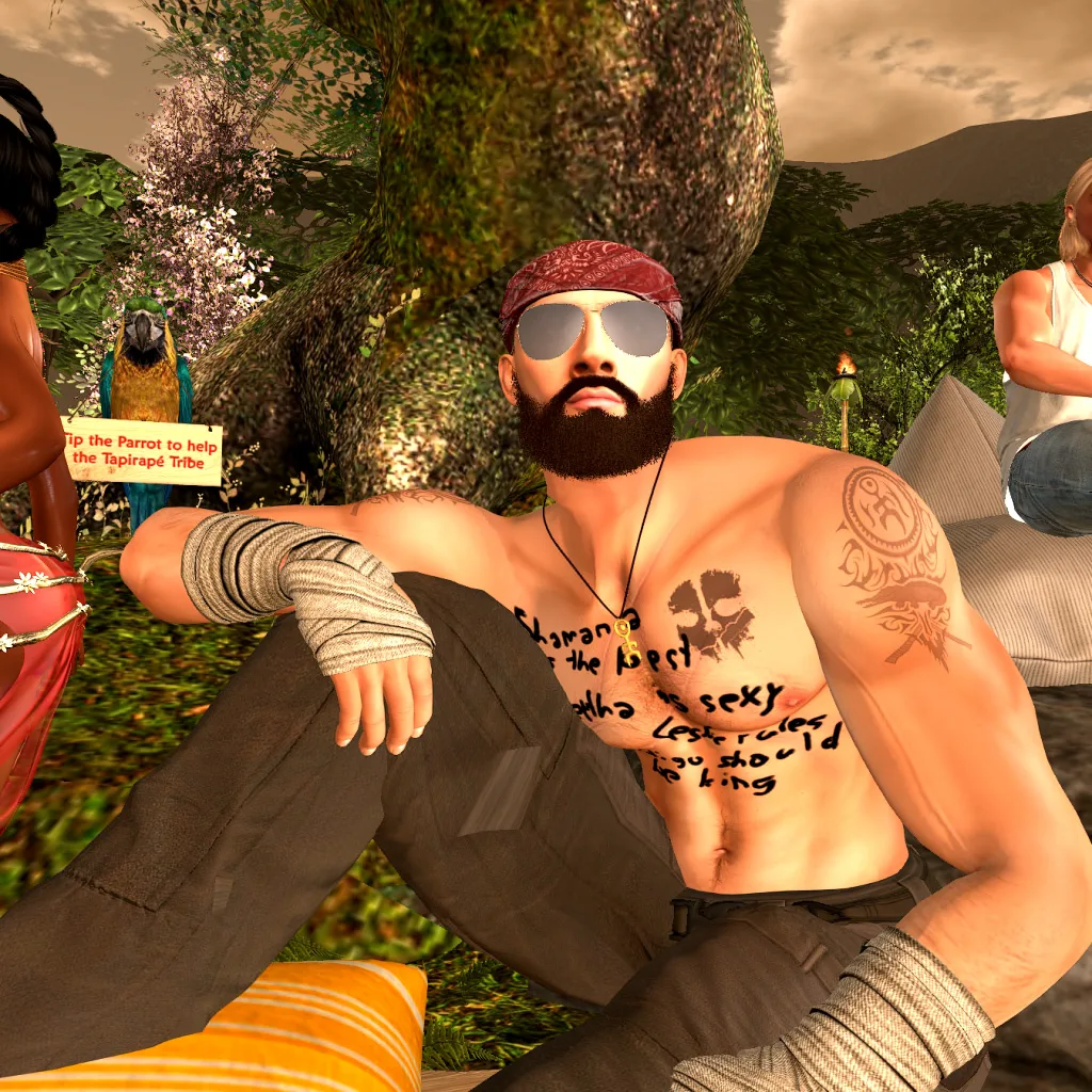 Shirtless villager with tattoos relaxes on cushions under a tree at jungle camp
