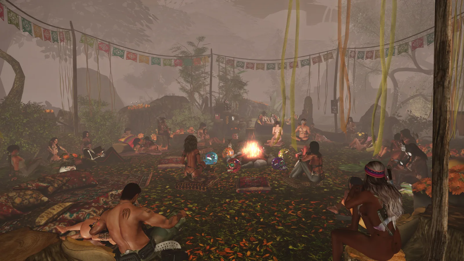 People gather around a central fire at a jungle camp under colorful banners