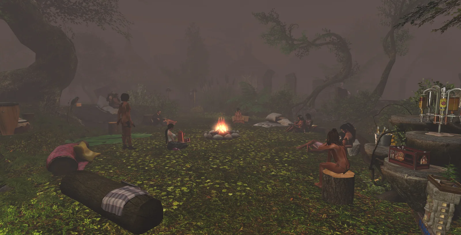 A group sits around a fire in a jungle camp, surrounded by mist and trees