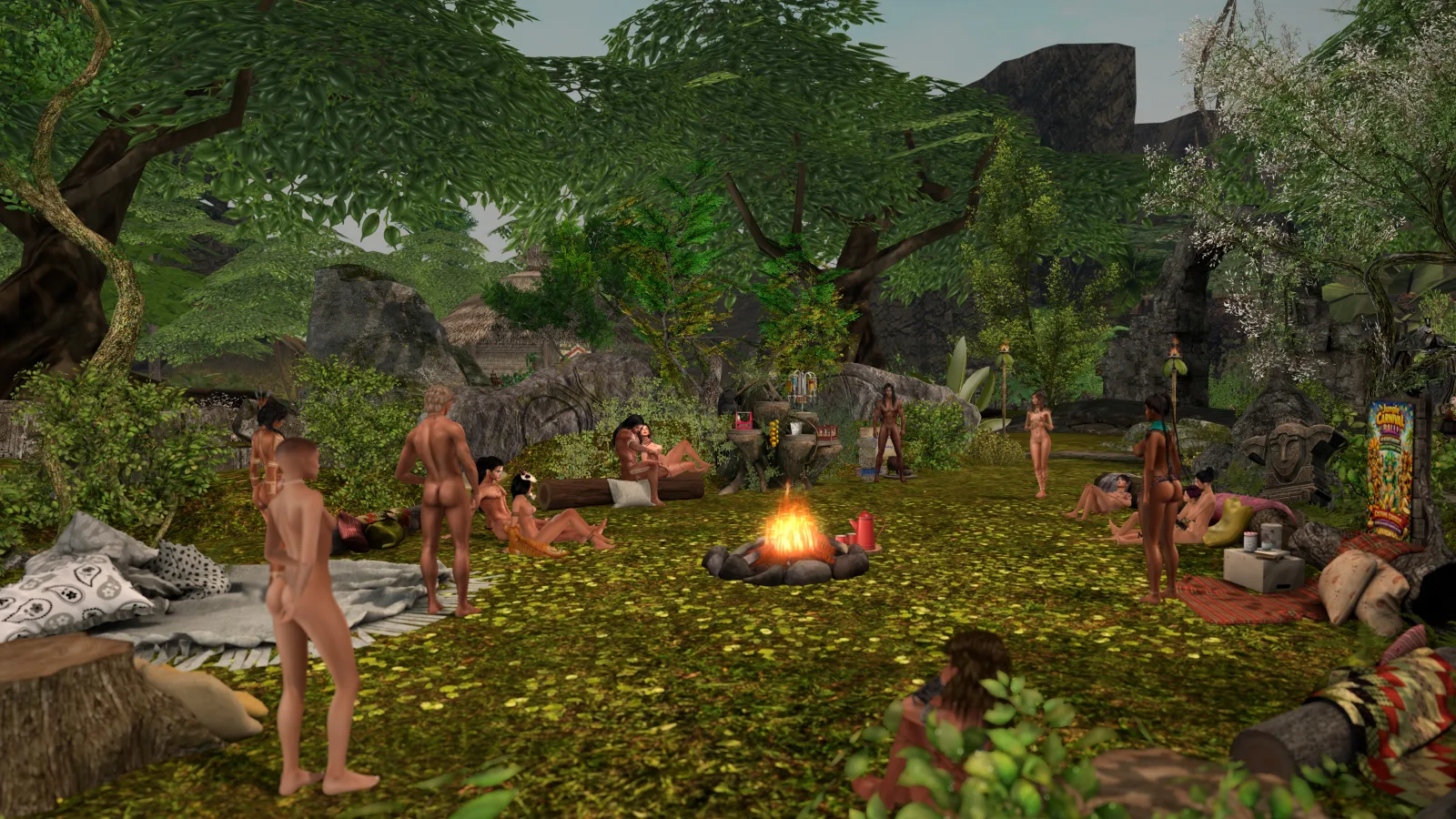 Villagers topless gather around a campfire in the jungle clearing